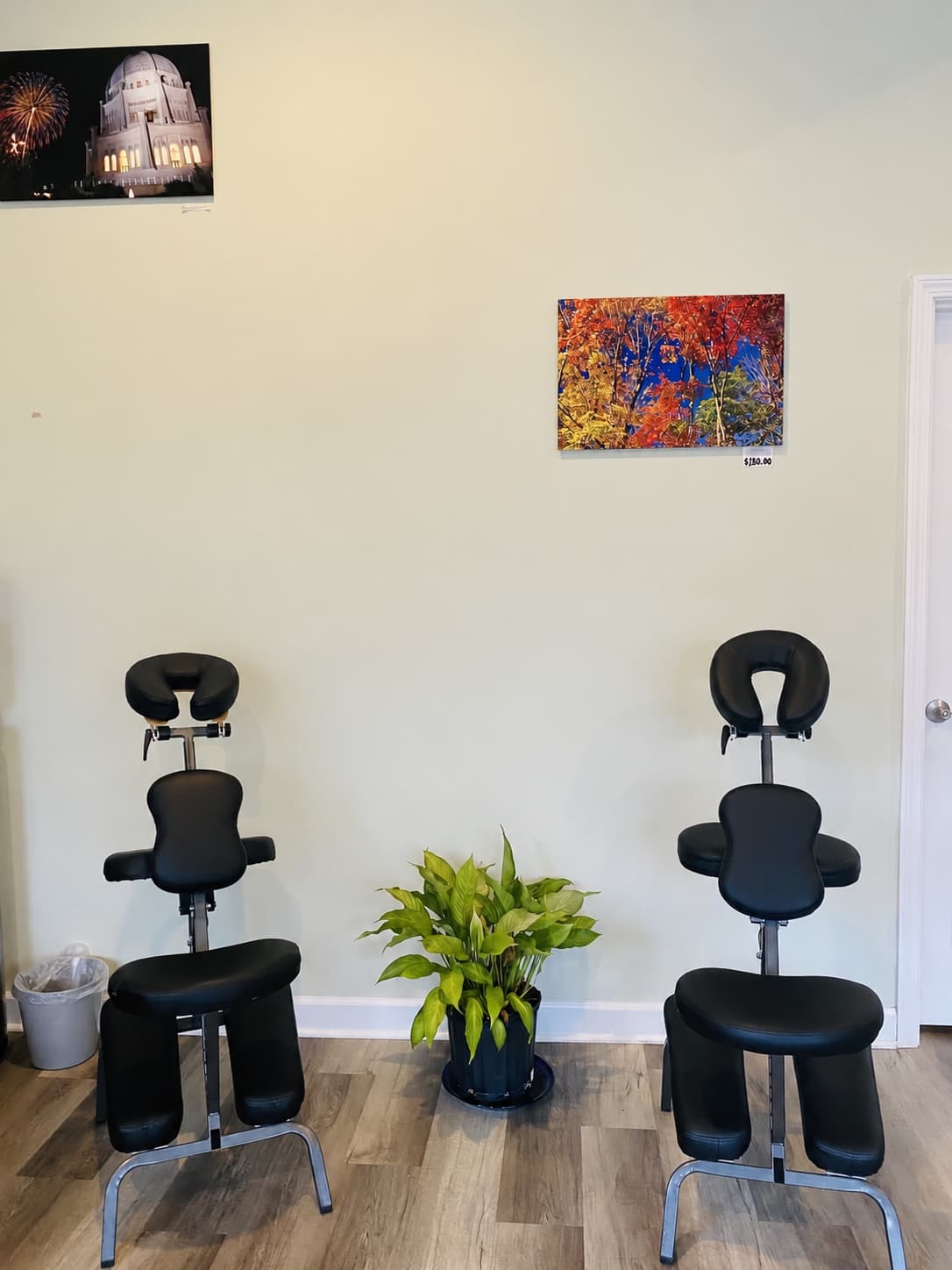 Two massage chairs with face cradles beside a potted plant in the Healot R Us studio